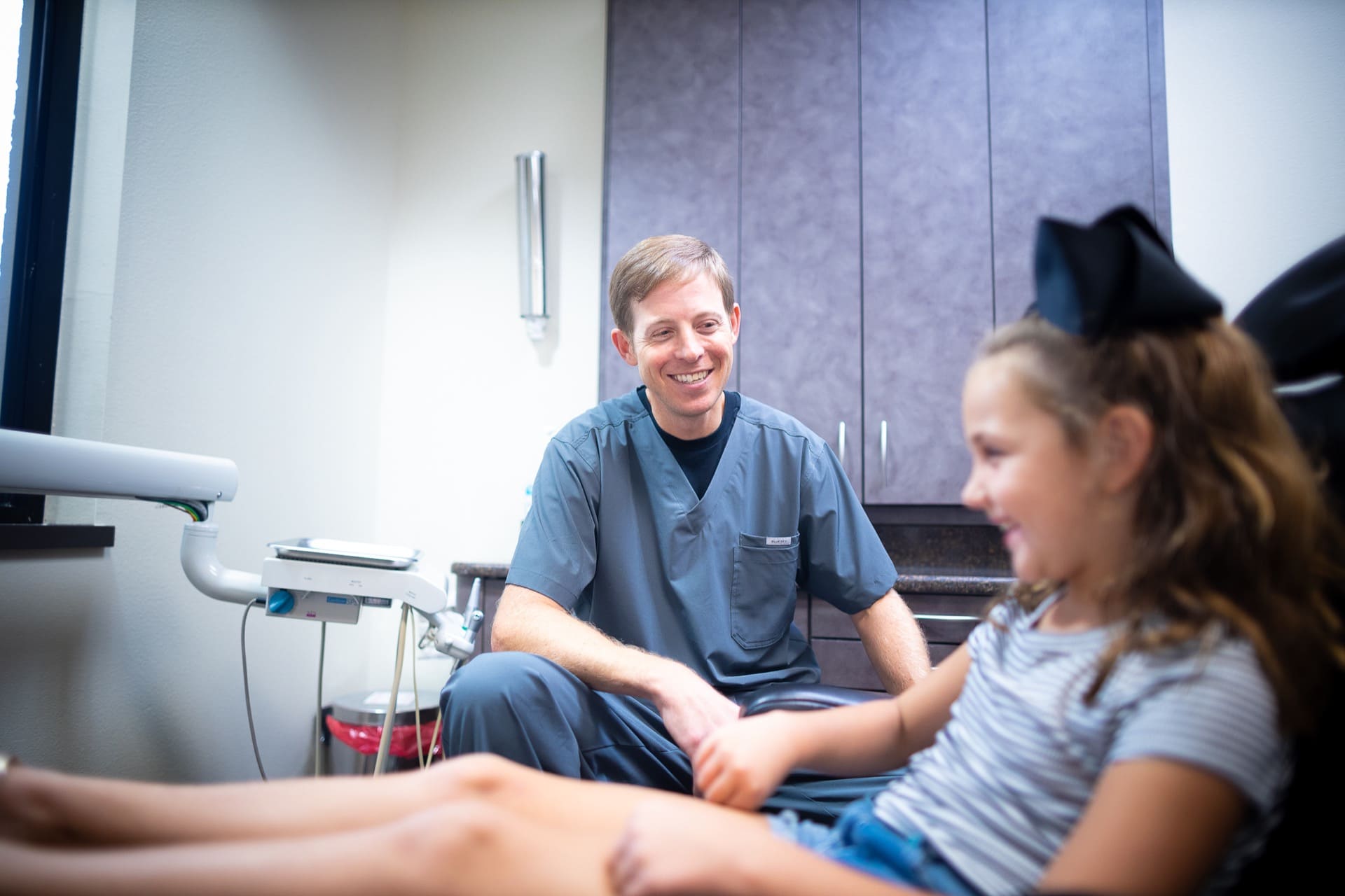 Healthcare provider examines patient's arm in modern clinical examination room.