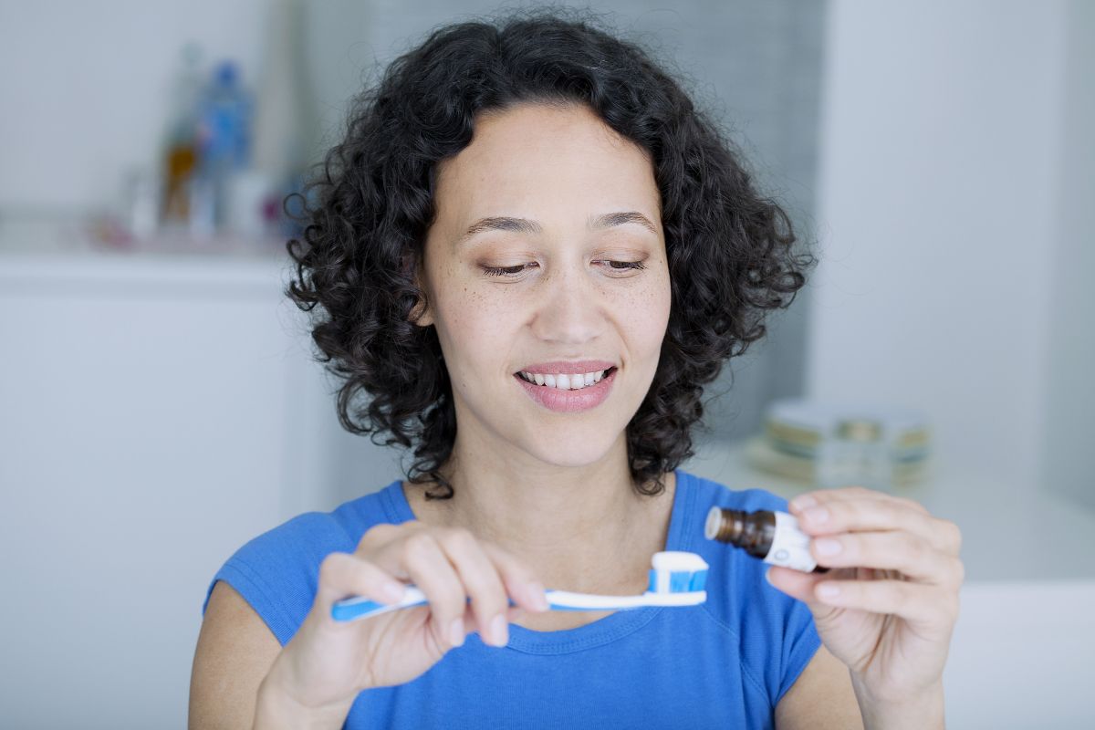 Woman in blue shirt holding and examining small blue objects in bright indoor setting.